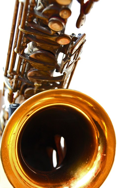 Un saxofón alto de latón visto de perfil, con la boquilla arriba y la campana abocinada abajo