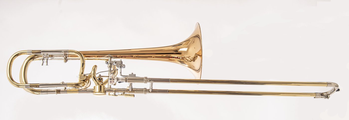 Un trombón bajo con la campana ancha, la vara y, en el centro, las dos válvulas de rotor con sus palancas de pulgar